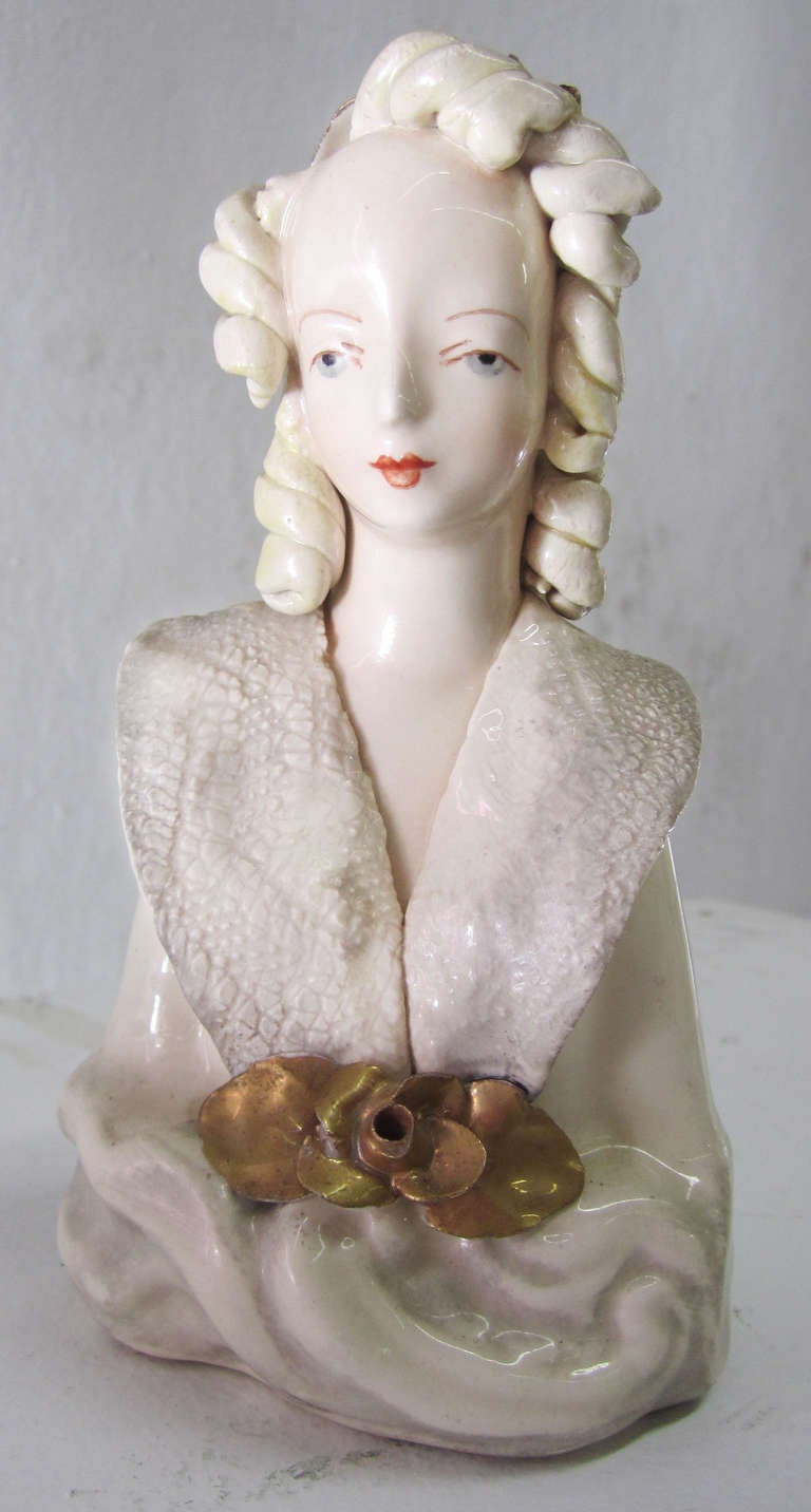 This petite bust of Victorian lady by Cordey was produced in the 1940s. The creamy porcelain woman features fine hand-painted details in her face and throughout. She is decorated with hand-formed hair and collar; the roses are finished with gold