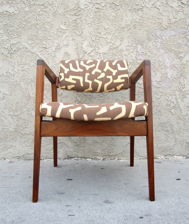 This excellent example of a Mid-Century chair by W.H. Gunlocke features a walnut frame with strong, clean angles that supports a slightly curved seat and back. These chairs retain their original upholstery with a very Mid-Century Modern brown and