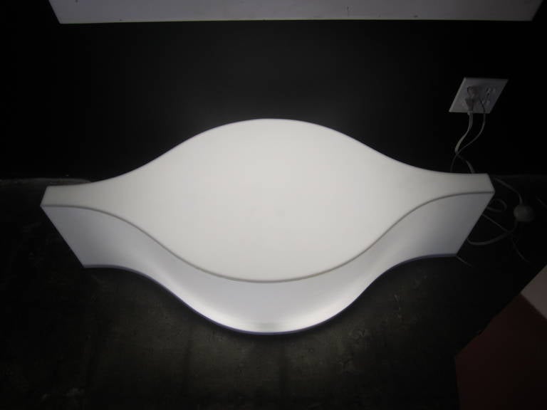This light-up Lucite table with a unique Arabesque shape illuminates from within and is coffee or side table sized. Operated via a push button located on the cord.