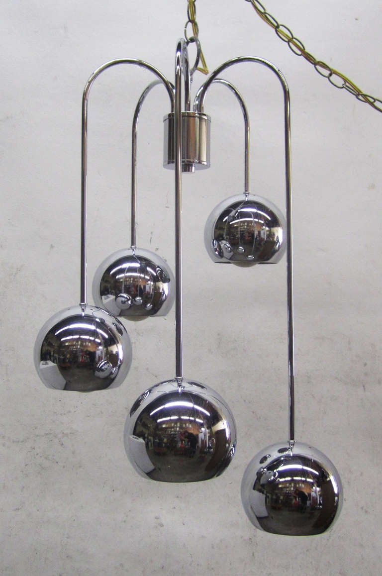 This hanging ceiling light from the 1970s features five polished chrome balls that arc from the center and spiral downwards.