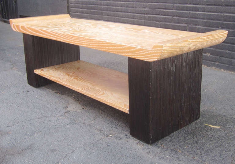 The Asian inspired design of Paul Frankl's coffee table for Brown Saltman features two tiers of cerused oak supported by ebonized combed  wood pillars on either side. The piece is stamped beneath by the manufacturer.