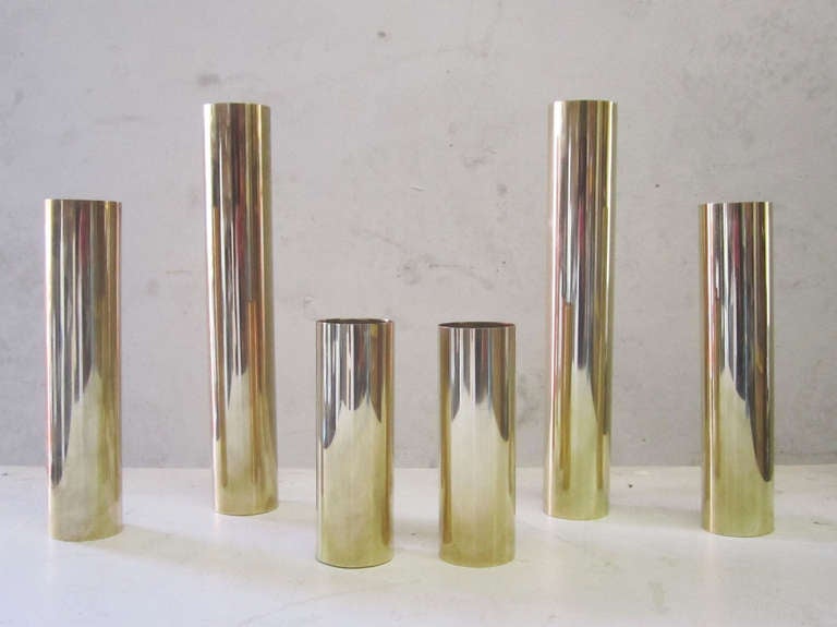 Set of six columnar candlesticks in varying heights rendered in brass by Curtis Jere. Each candlestick is 1.5