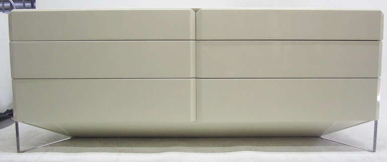 This sleek lacquer credenza by celebrated Montreal firm, Rougier, features six graduated drawers located on three tiers.
Each of these drawers opens to reveal a large storage space. The dresser rests on a unique lucite base and features beveled