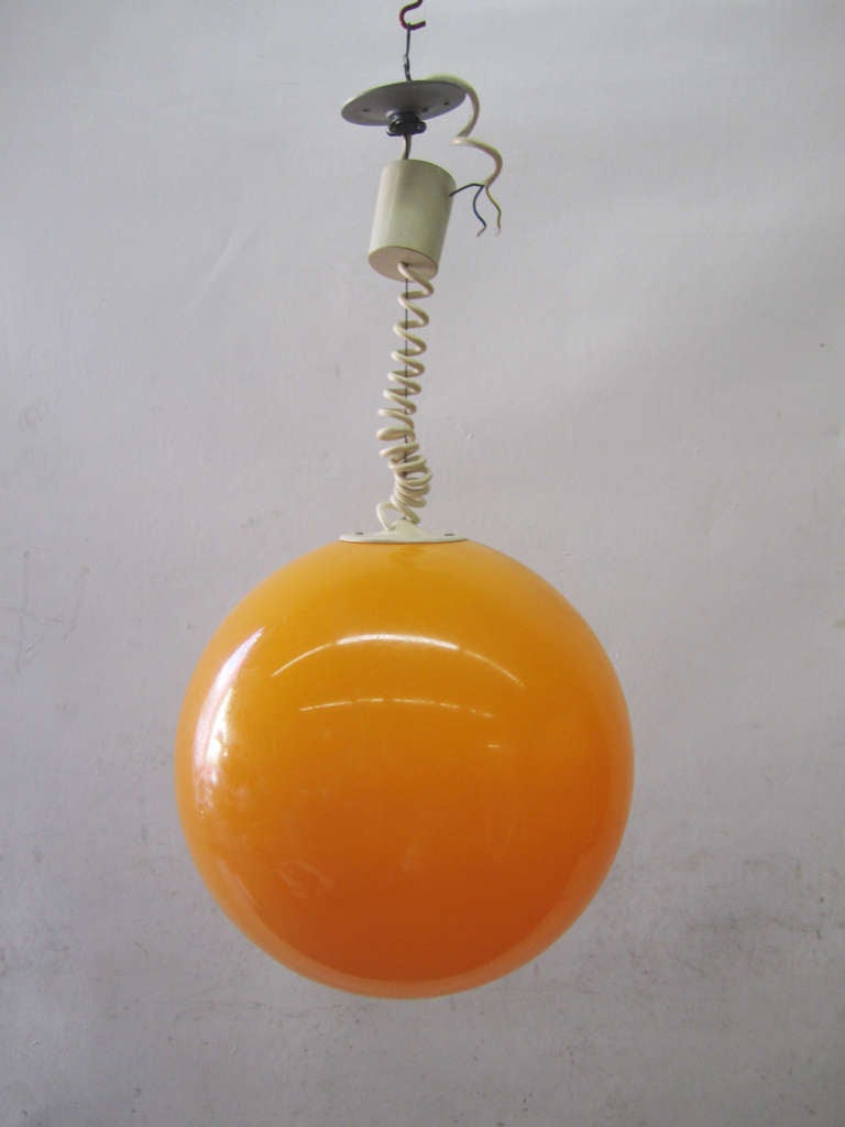 This cheerful orange pendant lamp is height adjustable and was produced in France during the 1970s.