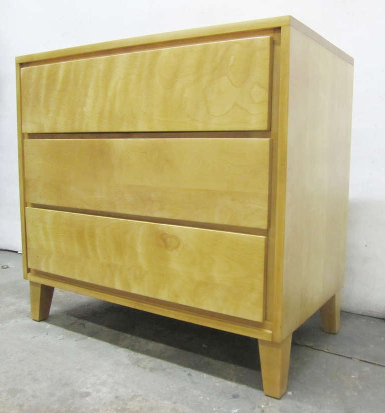 This Russel Wright chest of drawers is rendered in solid birch and features straight lines offset by tapered legs. The three-drawer dresser was part of Wright's 