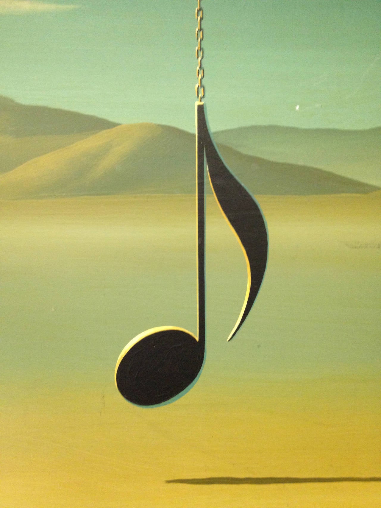 A surrealist oil painting of a single music note dangling from a chain against a desolate desert backdrop. This piece is signed in the lower left, 