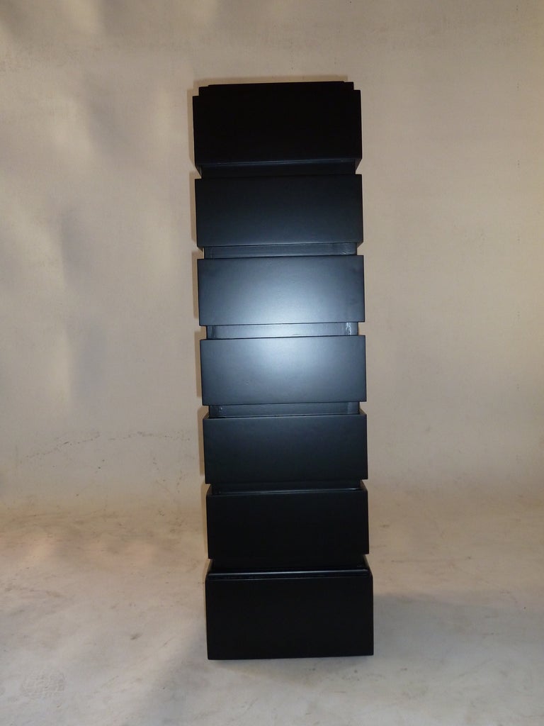 Pair of pedestals made of wood with a black satin lacquer . The pedestals are architectural in design that tower upward.
