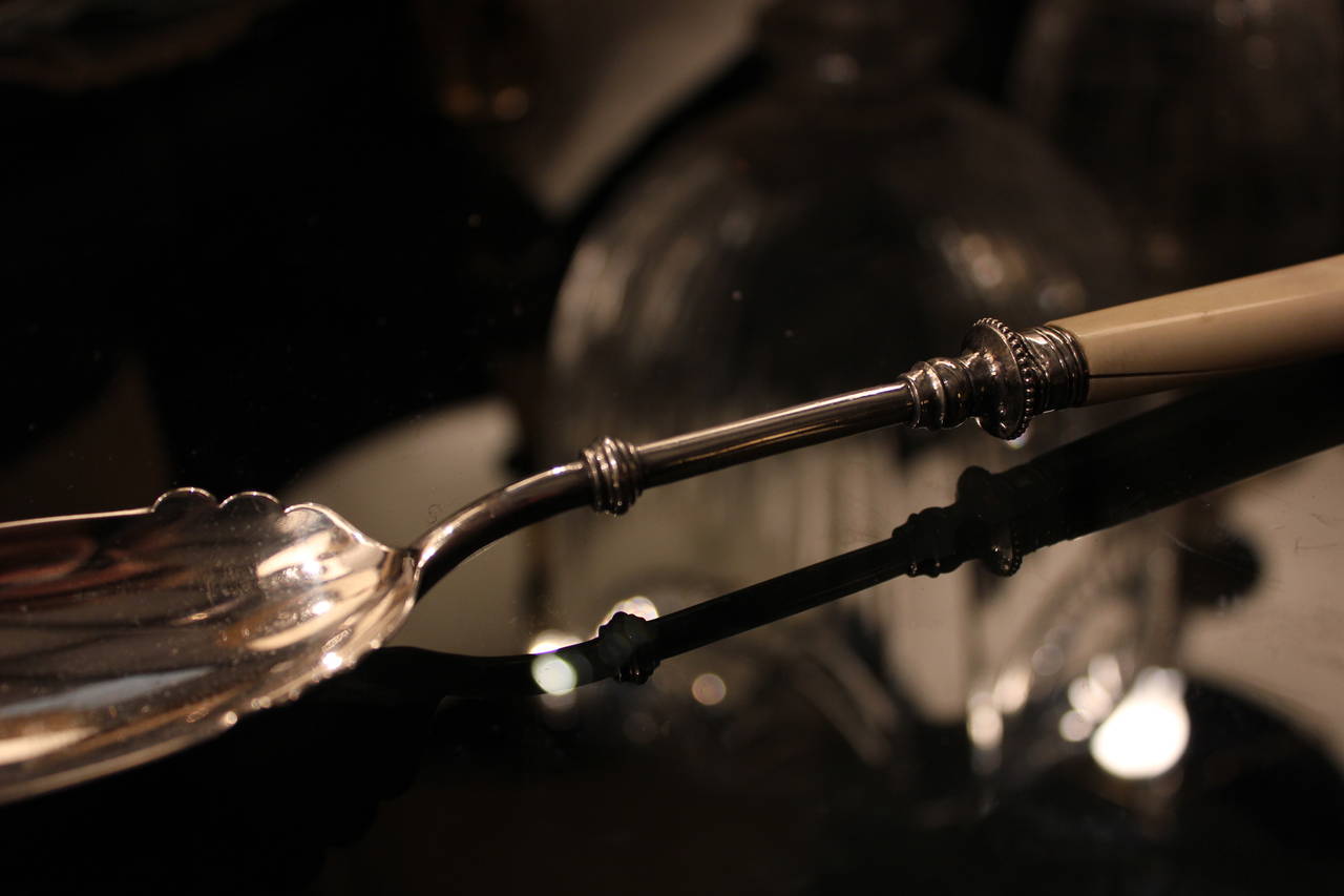 Early 20th Century silver plated spoon with bone handle. Scalloped edges on spoon. England.