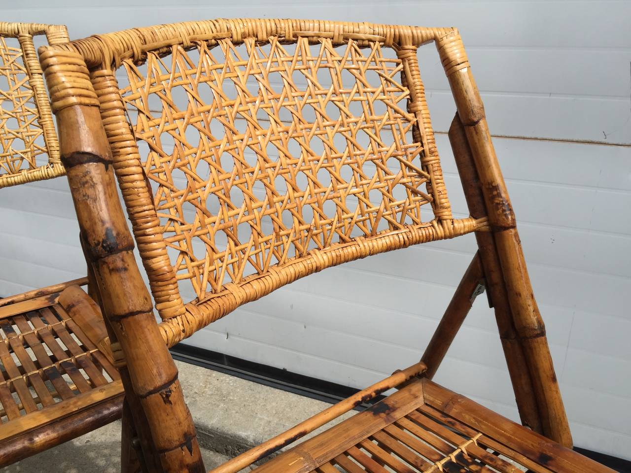 This is a remarkable set of 5 individually unique Scroched Bamboo frame folding seats.  The seat and back are made of rattan.  Excellent set.