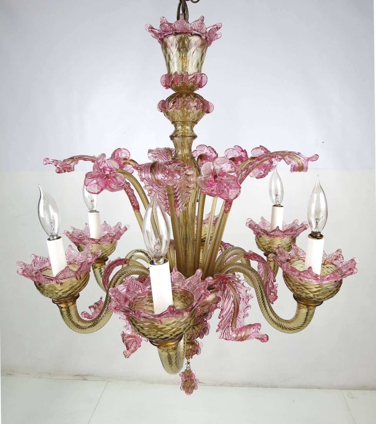 Beautiful vintage Murano six-arm chandelier with plumes and flowers in amber and pink glass, suspended with a cast bronze bulb form chain. The chandelier is in perfect condition with no breaks, losses, or repairs.