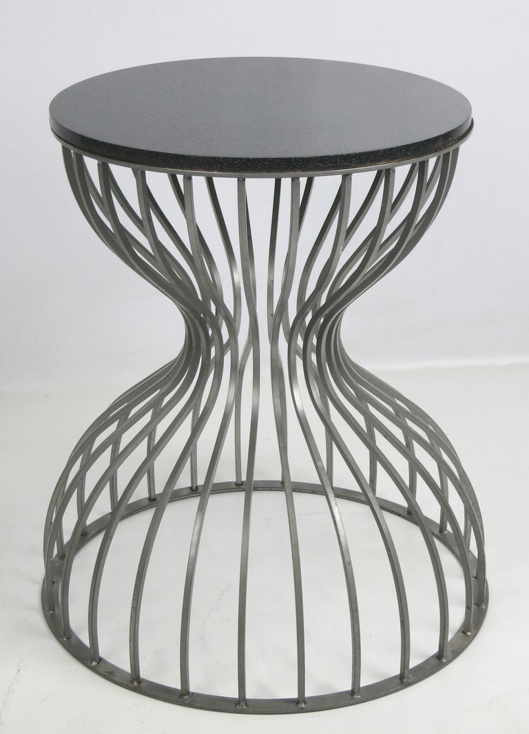 Hourglass form steel cage side tables.  Tops are black Corian that can be substituted with glass or stone of choice.  

Dimensions-

Bottom diameter- 18.5