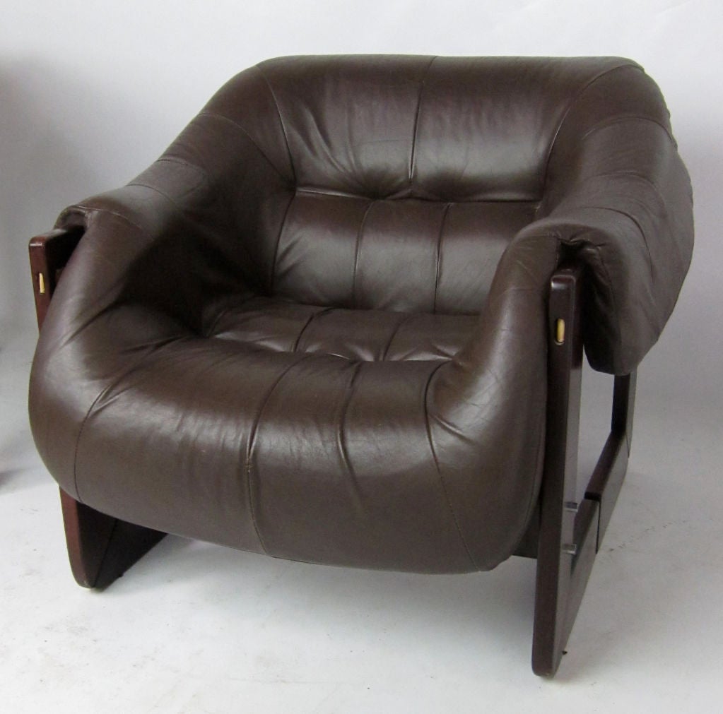 Dramatic Modern pair of Lounge Chairs by Percival Lafer.  These incredibly comfortable chairs are upholstered in dark brown glove leather draped over a Rosewood and leather sling frame.  Leather has beautiful age and patina.