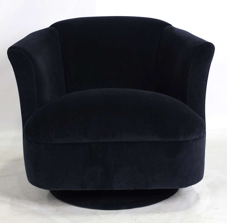 Sumptuous pair of rock and swivel Club Chairs freshly upholstered in luxurious deep Navy Blue Velvet.