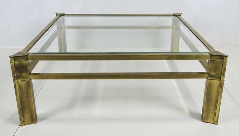 Large Sculptural Brass Cocktail Table by Mastercraft.  This finely crafted table in antiqued brass has an inset beveled glass top and triangular corner supports.  The table is in mint, like-new condition.