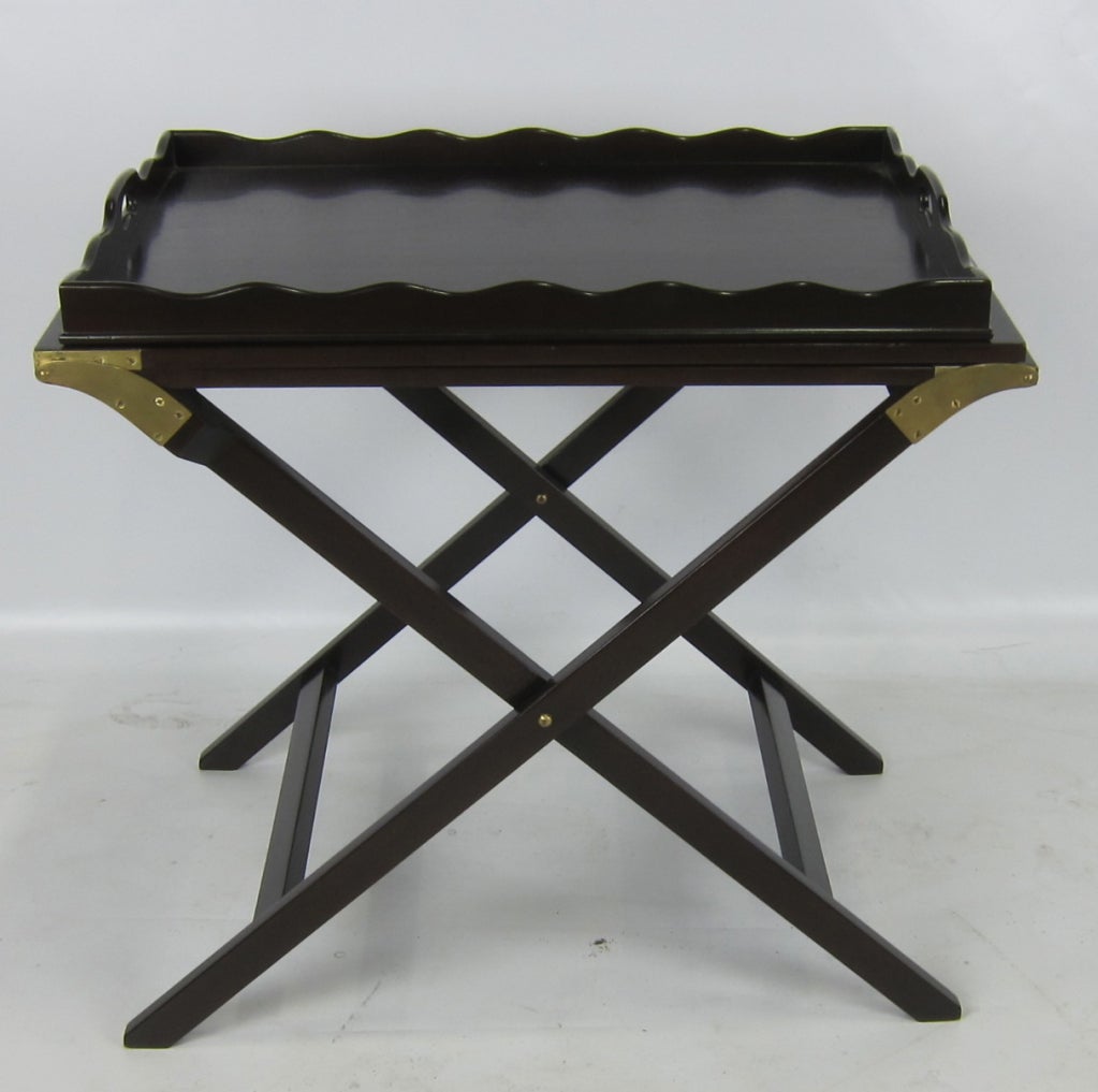 Beautifully crafted Tray Table with Scalloped edge Mahogany tray on a Campaign style base.  The hinged leaves fold out and the polished brass supporting legs screw into the underside.  Solid Brass mounts and legs.  It can be folded up as shown in
