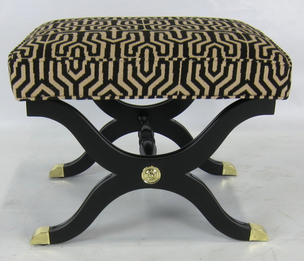 Regency Style X-base Stool with Brass sabots and medallions.  The piece has been meticulously restored in black lacquer, with polished and lacquered mounts and fresh upholstery.