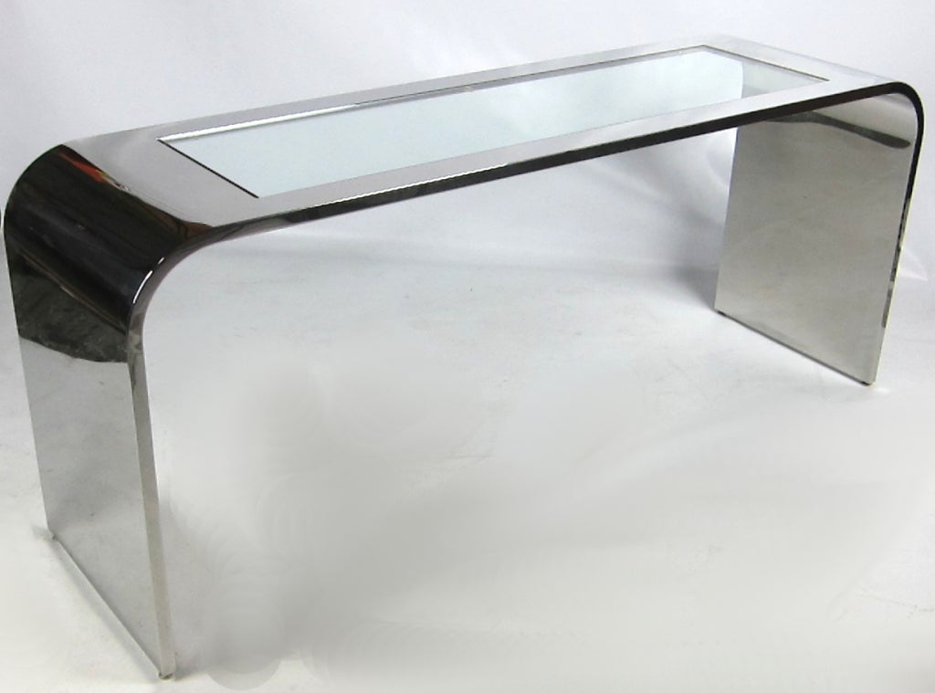 Large-scale mirror polished stainless steel console or sofa table with inset glass top by Stanley Jay Friedman for Brueton. Raised on adjustable steel glides. Top quality materials and workmanship throughout on this very impressive piece. 

From