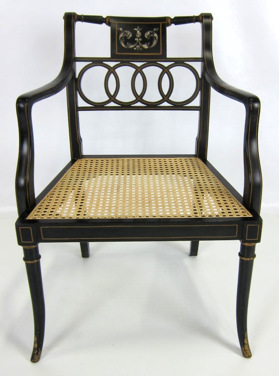 Regal pair of Italian Regency armchairs with caned seats and gilt decoration.  Cane seats have been replaced.  Seat cushions are included as form