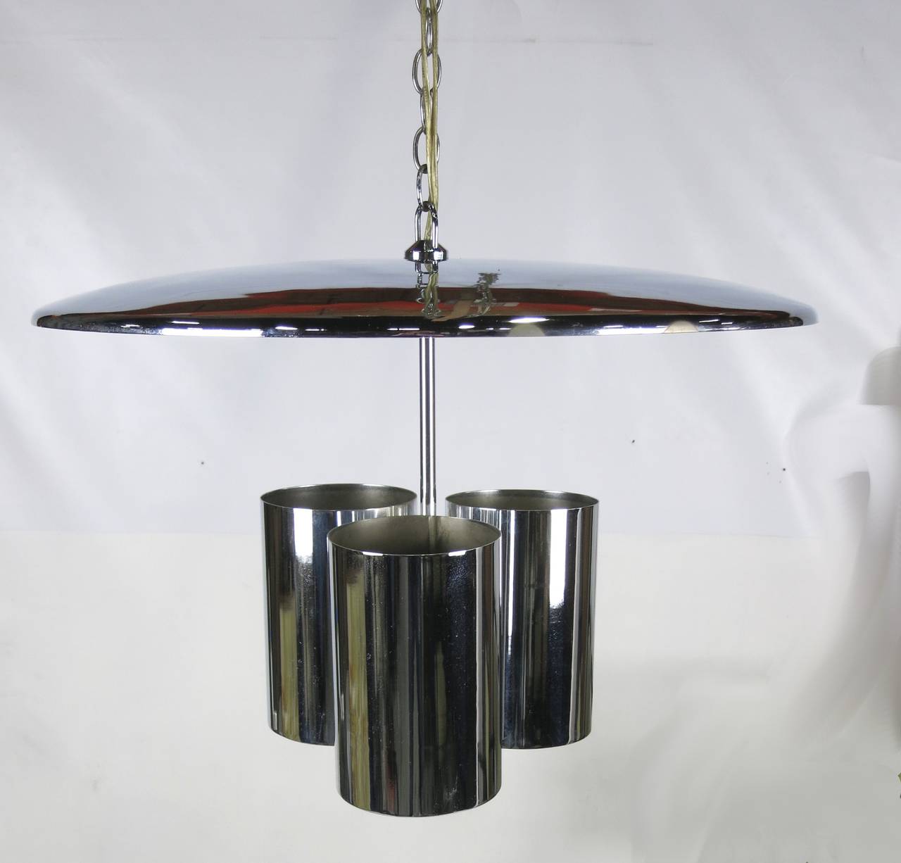 Handsome chrome saucer chandelier with three uplights that illuminate the white underside of the shade for a dramatic indirect light. Comes with 10' of  original chrome chain.  It has the feel of a George Nelson 