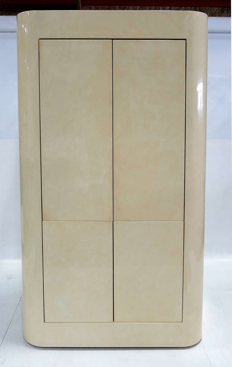 Beautifully crafted and finished faux Parchment lacquer Bar Cabinet.  French Polished mottled Ivory finish.  The doors of the top section retract into the cabinet.  