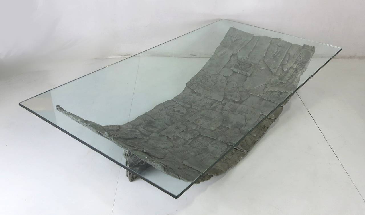 Huge sculptural aluminum coffee table in the style of Donald Drumm or Silas Seandel. The piece is constructed of overlapping layers of hammered aluminum with wedge bases.