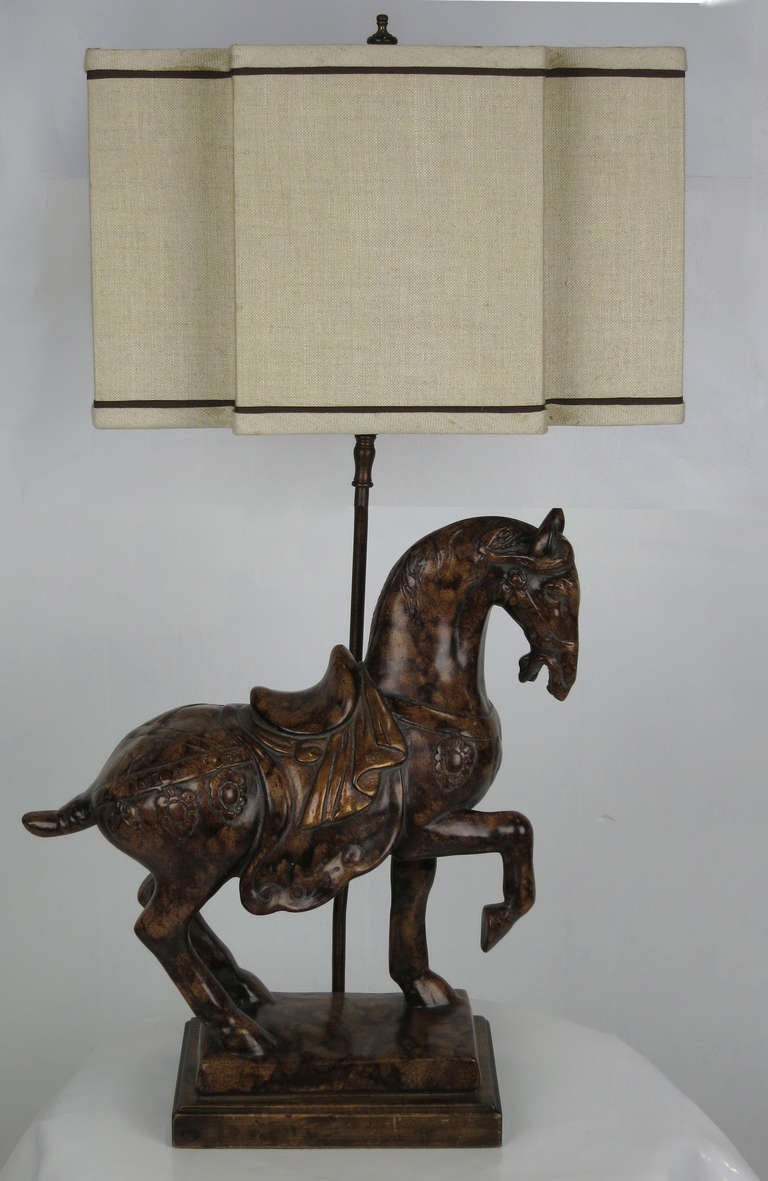 Large cast figural Tang horse  lamp with a beautifully rendered Faux Marbre finish mounted on a wooden base.  Figure alone measures 17.5 x 16 x 6.  The shade is for display only and is not included.

34
