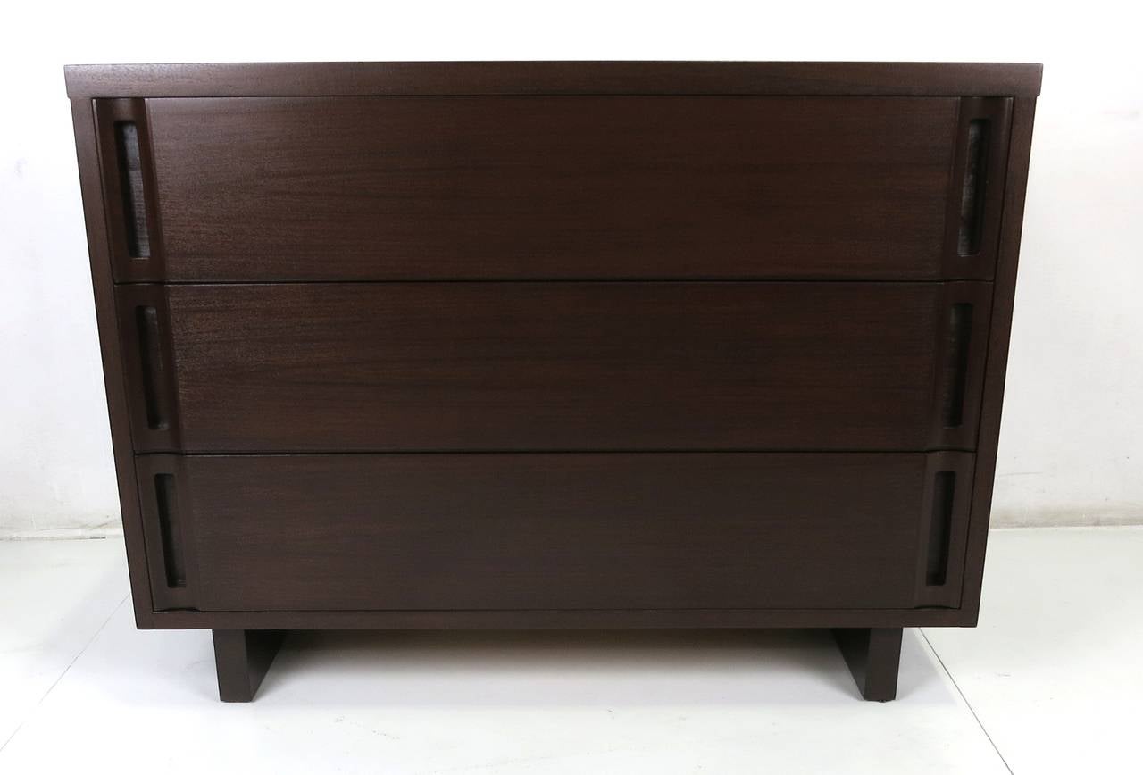 Fine pair of Walnut Bachelors Chests. This beautifully crafted pair are raised on sled bases and the drawers are opened by inset integral finger pulls on both ends of each drawer. The pair have been meticulously restored in dark walnut open grain