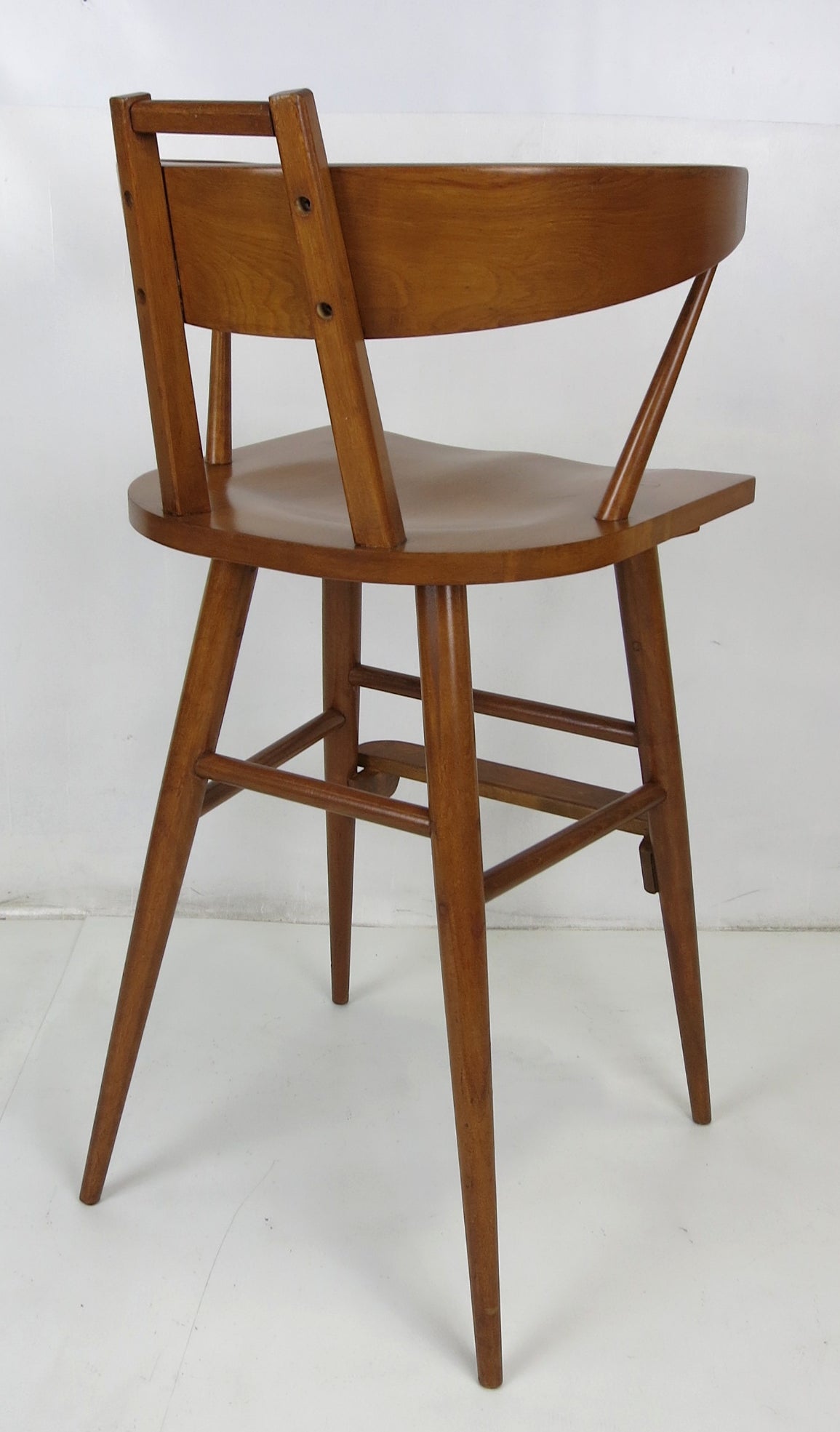 Pair of Mid-Century Modern bar stools in the style of Paul McCobb. The pair have been completely restored; glued up and refinished but left with all of their vintage charm.