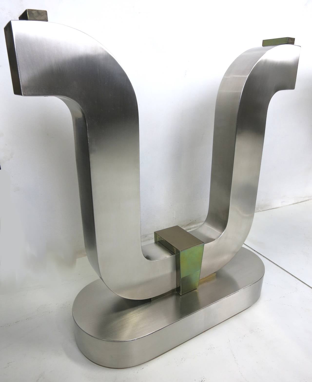 Impressive pair of large scale brushed steel table bases consisting of harp form supports raised on oval plinths with solid brass footings.  Top quality materials and workmanship with seamless welds on all pieces reminiscent of similar items by Jay