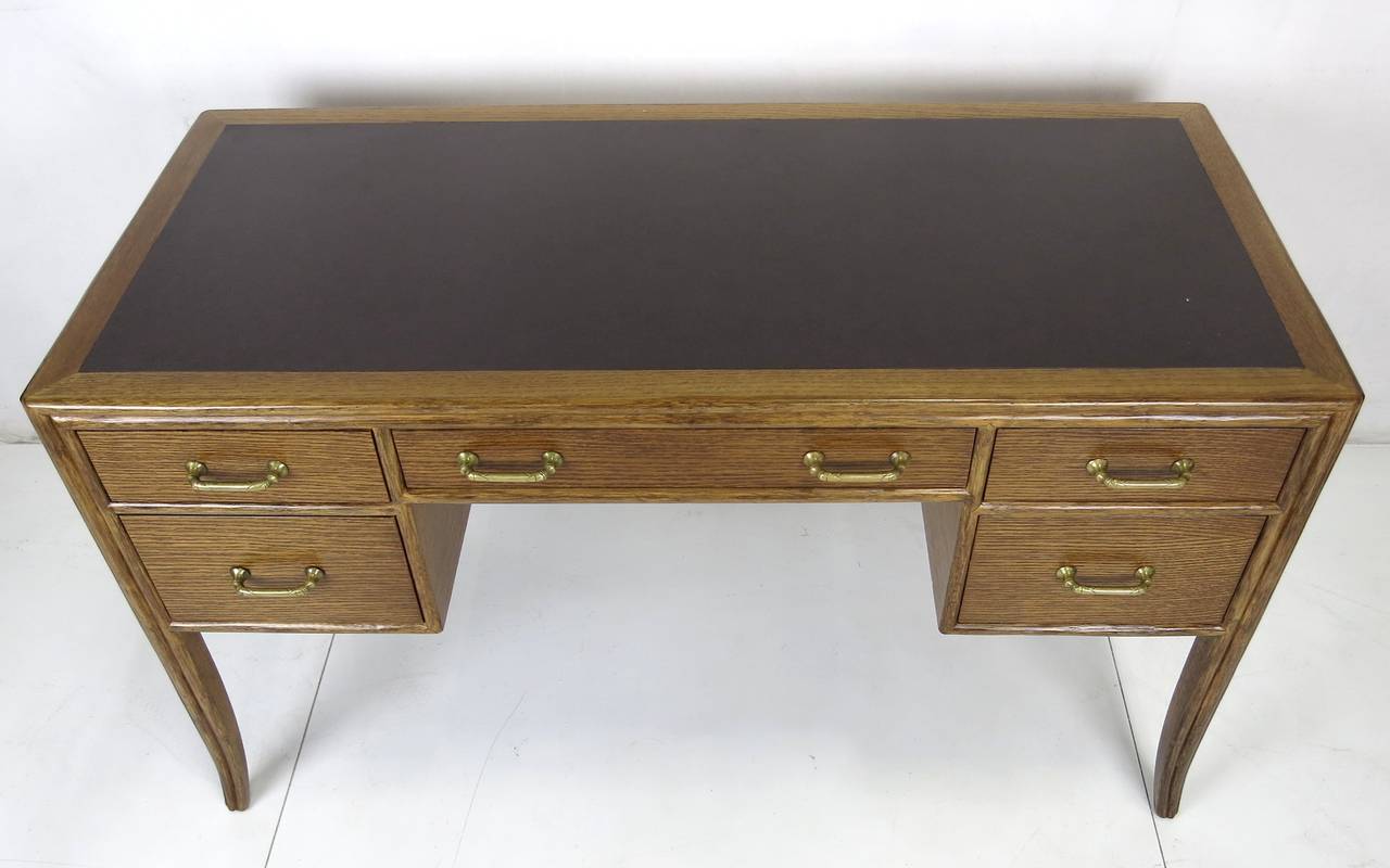 Classic McGuire rift oak desk with rattan trim, inset laminate top and brass pulls designed by Eleanor Forbes for McGuire. The desk is in excellent original condition.
