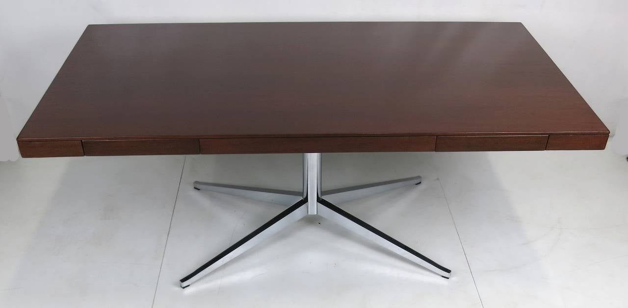 Fantastic and iconic partners desk in walnut by Florence Knoll for Knoll Associates. The desktop and drawers have been meticulously refinished in the original color and the base is in excellent original condition with no losses to the plating. The