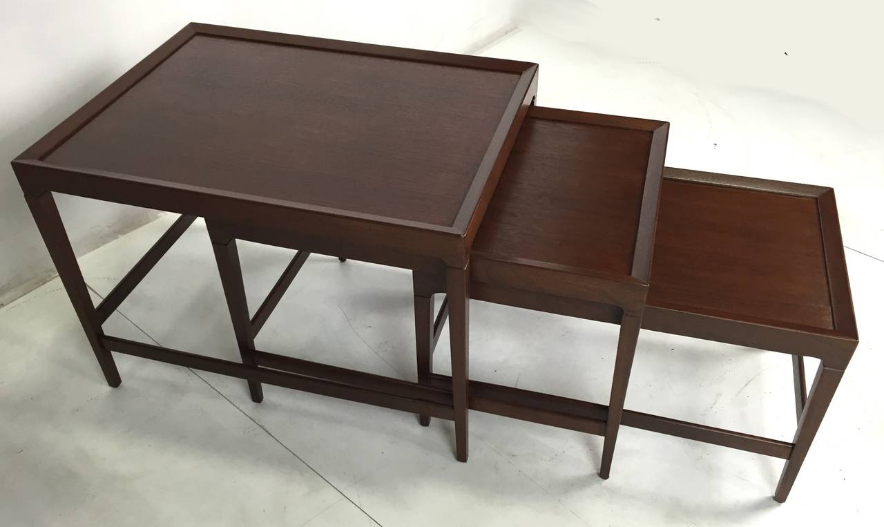 Beautifully figured set of three nesting tables featuring fine hand craftsmanship attributed to Harvey Probber. Top quality materials and workmanship. Meticulously refinished in medium dark walnut lacquer.

Dimensions-
Large 28 x 21 x 20.
Small