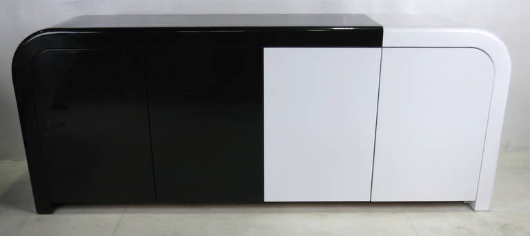 High end custom buffet cabinet  freshly refinished in a deconstructed black and white French polished lacquer finish. The interior is fitted with adjustable shelves and shallow drawers on both sides. The doors can also be rearranged in any
