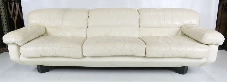Pair of 80's Italian leather sofas raised on black enameled triangular feet in their original distressed white leather from the 