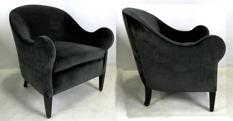 Unique pair of early modern lounge chairs with upward curved armrests. This unusual sculptural form is extremely comfortable. The pair have been completely restored, refinished and reupholstered in luxurious heavyweight charcoal grey velvet. Legs