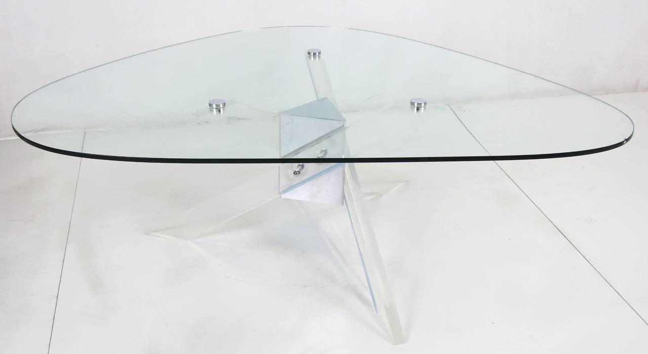 Cool 1970s cocktail table with three Lucite supports fixed to a central mirror polished stainless steel fixture. Free-form top is fixed to the base by threaded chrome buttons.