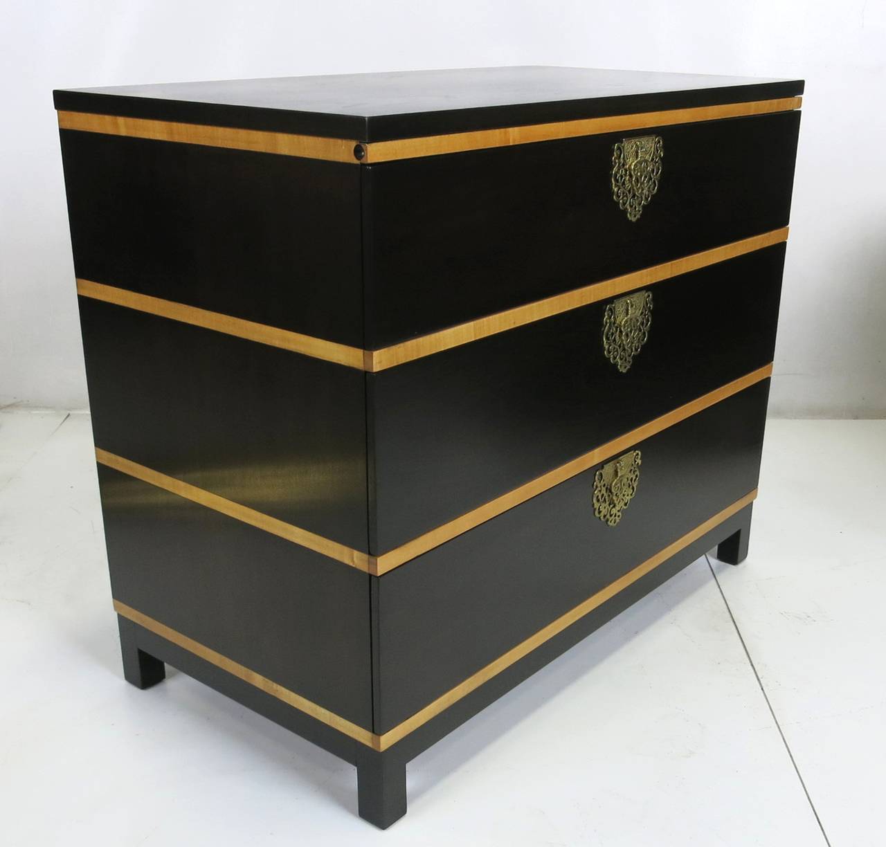 Handsome walnut bedside chest with contrasting ribbon Maple inlay.  Features a pullout shelf and elaborate bronze Moorish style hardware. The piece has been meticulously refinished in dark brown lacquer.