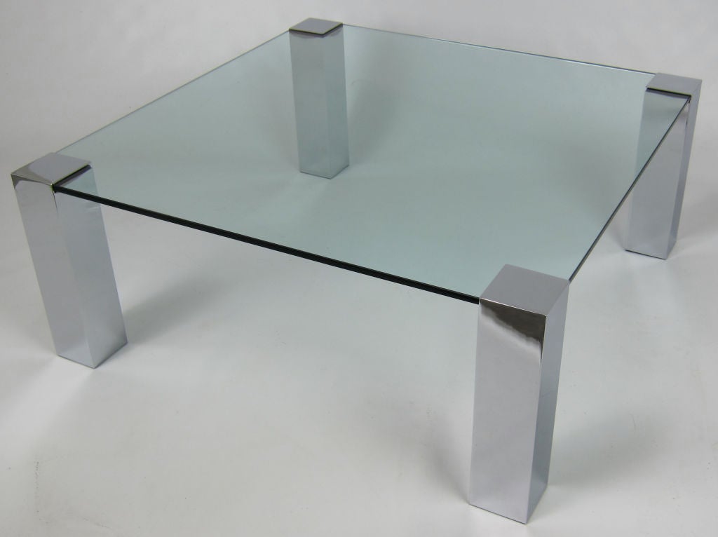 Modernist Coffee Table with Four Square Chrome Columns supporting a thick glass top.  Shape and dimensions of the glass top can be adjusted to order.