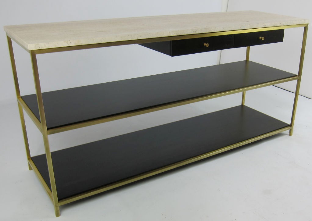 Rare Directional Console Table by Paul McCobb, mfr'd by Calvin, McCobb's finest and most sought after work.  The brass framed table features dark Mahogany undershelves and drawers, and a Travertine top.  The piece has been completely restored to