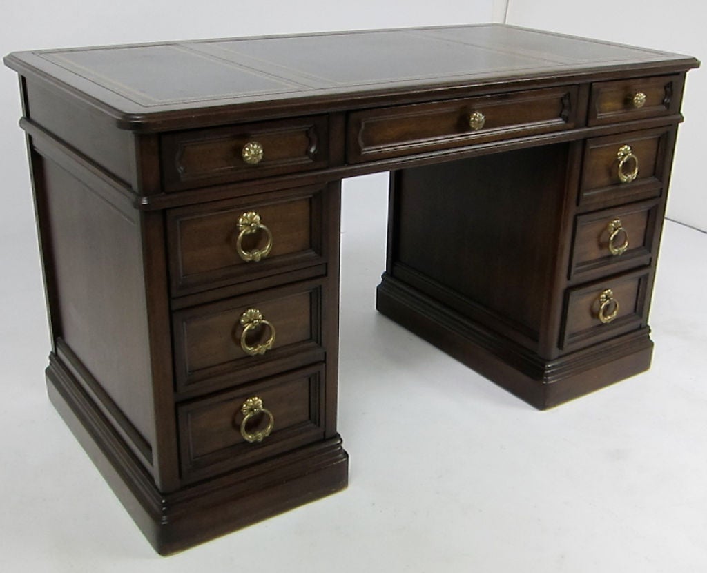 Writing Desk in Walnut with embossed border Leather top by Sligh of Holland, Michigan.  Sligh was contracted to make many of the high end desks and casework for Baker during this period and the company was acquired by Baker in the sixties.  Solid