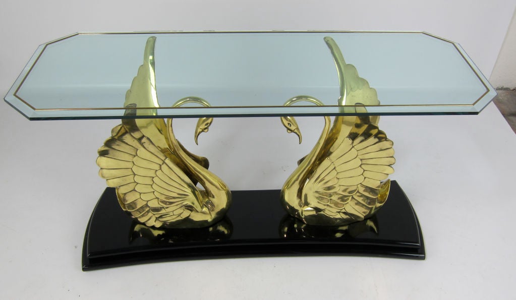 Large pair of beautifully cast brass swans supporting a beveled glass top with applied brass moulding.