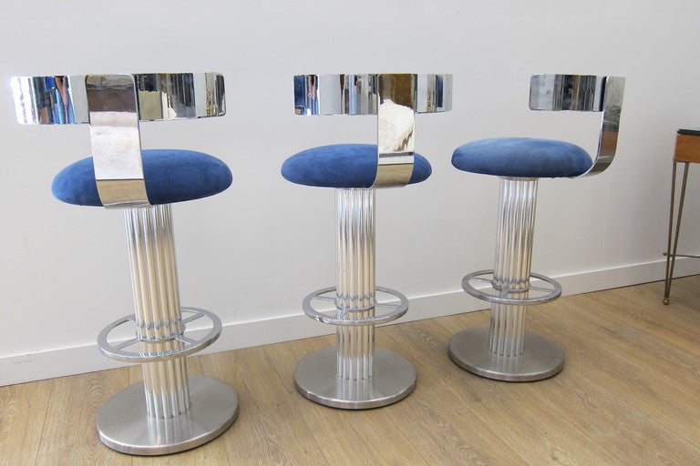  Superb group of three solid  chrome plated bar stools, seats swivel, Klismos style back. Upholstered with blue suede.
High back is 39