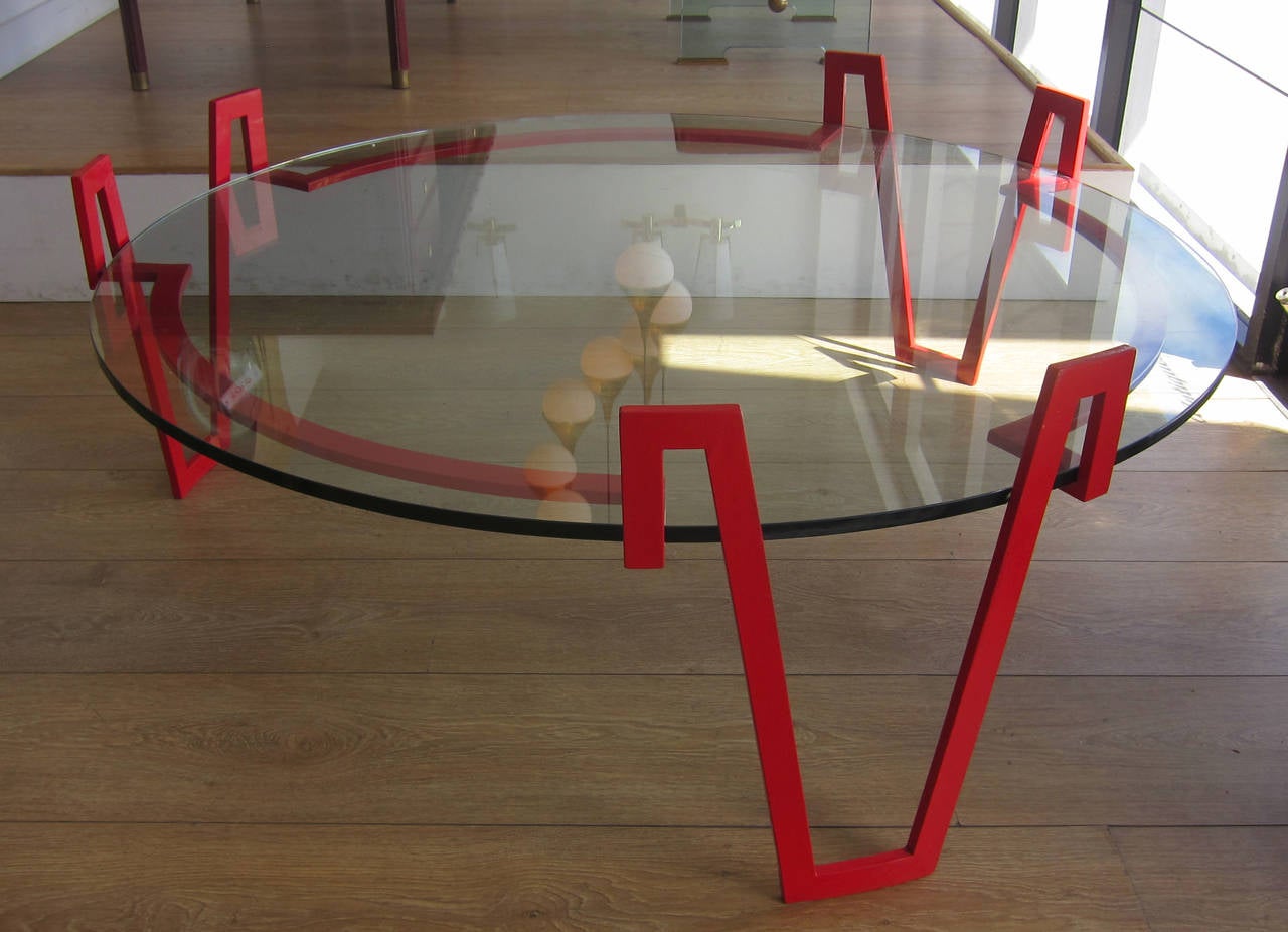 A large red lacquered wrought iron coffee table in the style of Jean Royère.