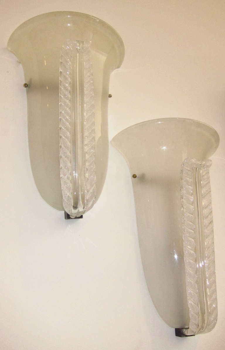 Opaline glass wall lights, demilune shape, brass fittings.