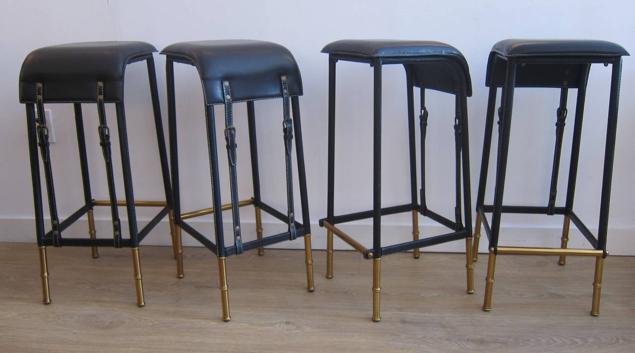Rare suite of four black stitched leather bar stools with faux bamboo brass legs, by Jacques Adnet, France, circa 1960s.
Legs are newly brass-plated, leather is restored to perfection.