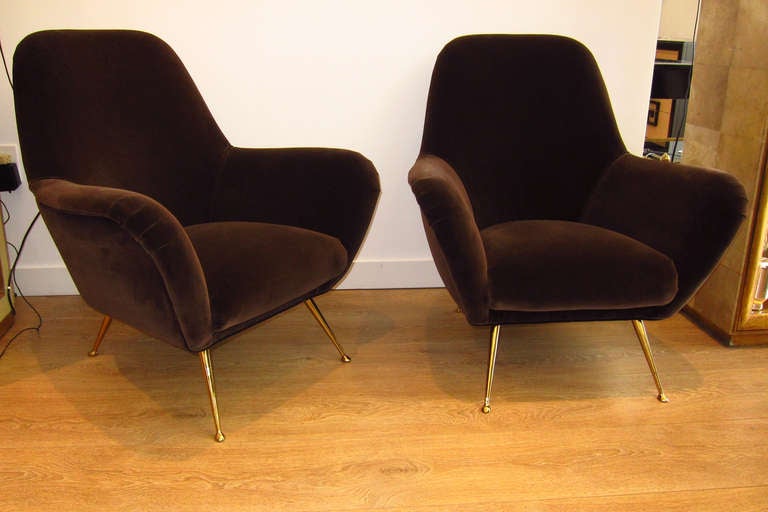 A pair of Italian circa 1950's lounge chairs, newly upholstered with chocolate-brown velvet, splayed and tapering brass legs.
THIS ITEM IS LOCATED IN MANHATTAN AT 1STDIBS@NYDC SHOWROOM. 
200 LEXINGTON AVE - 10TH FLOOR, NYC.