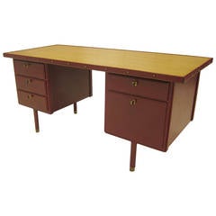 Bureau en cuir cousu rouge de Jacques Adnet.