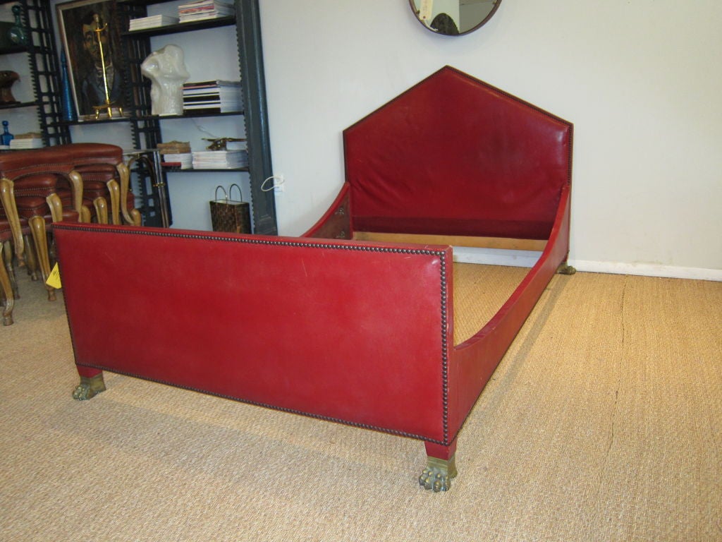An amazing full size Empire style bed, wrapped in original red leather with nail trim, superb bronze paw feet.