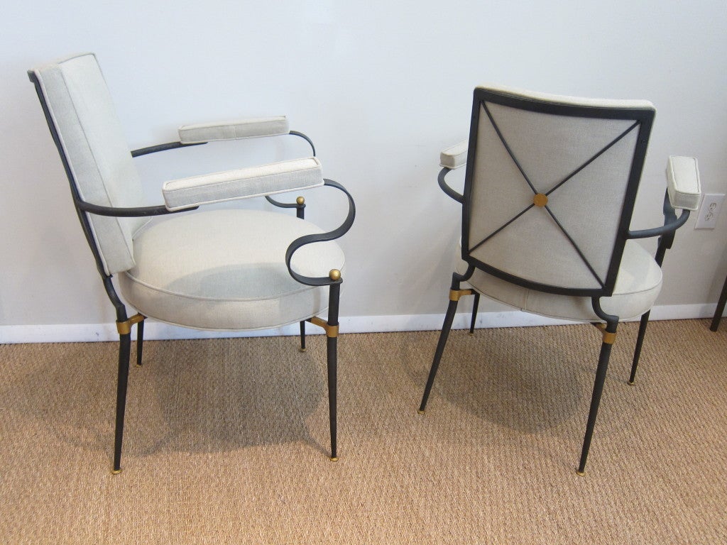 Rare and elegant 1940's French arm chairs, black iron structure with gilded accents. Newly upholstered with silk linen.