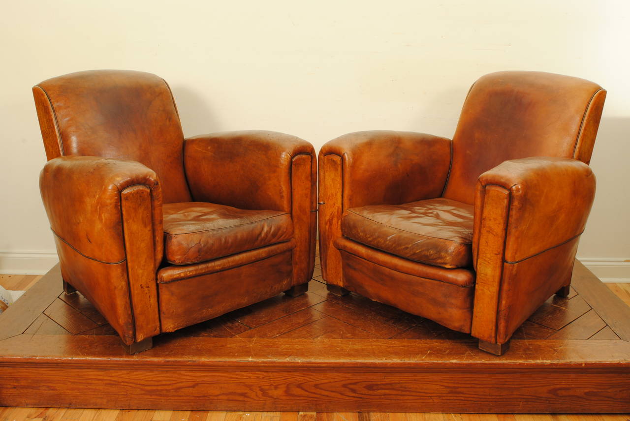 Pair of Art Deco club chairs with no rips, no tears, no losses, deep and comfortable, nice darker colored piping.